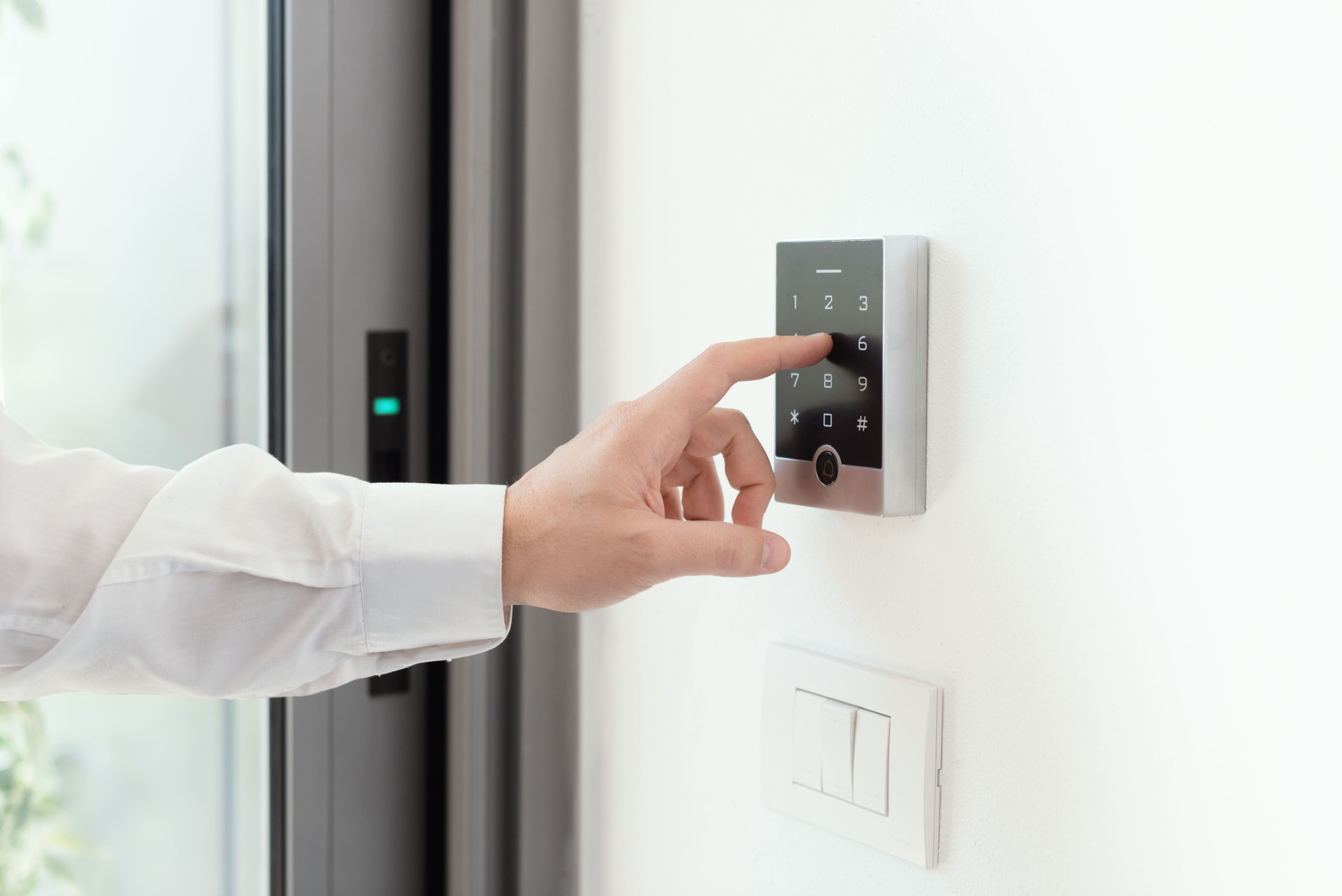 Mann, der einen Alarmcode für die Sicherheit zu Hause einstellt